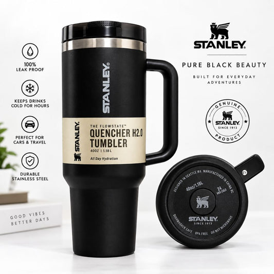A black Stanley Quencher H2.0 tumbler with a handle, shown alongside its matching black lid on a white background with product feature icons and branding.